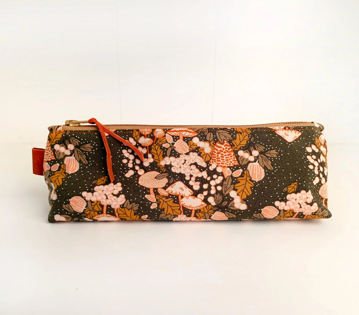 Artist brush case with autumn mushrooms print.